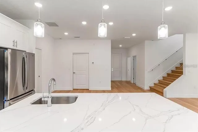 a view of a kitchen with a sink and refrigerator