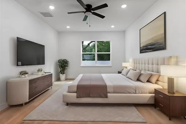 a bedroom with a large bed and a flat screen tv