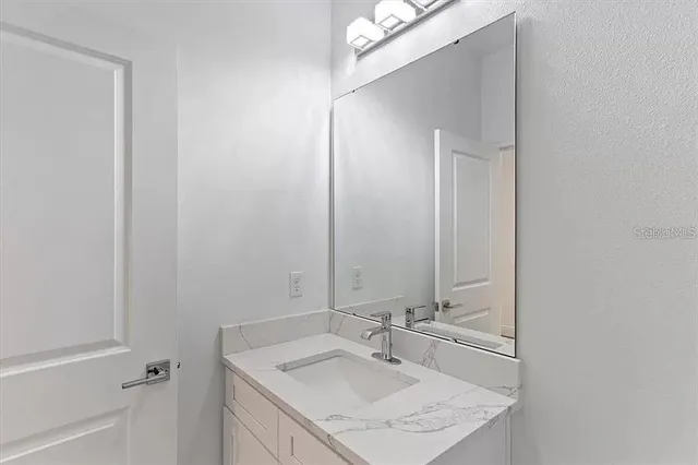 a bathroom with a sink vanity and a mirror