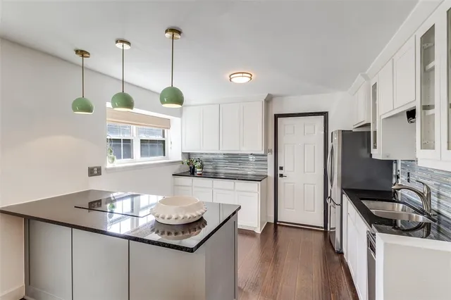 a kitchen with a sink a stove a refrigerator and wooden floor