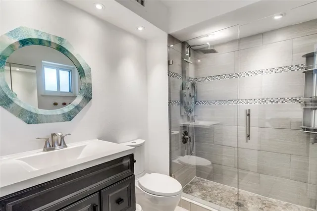 a bathroom with a sink a toilet and shower