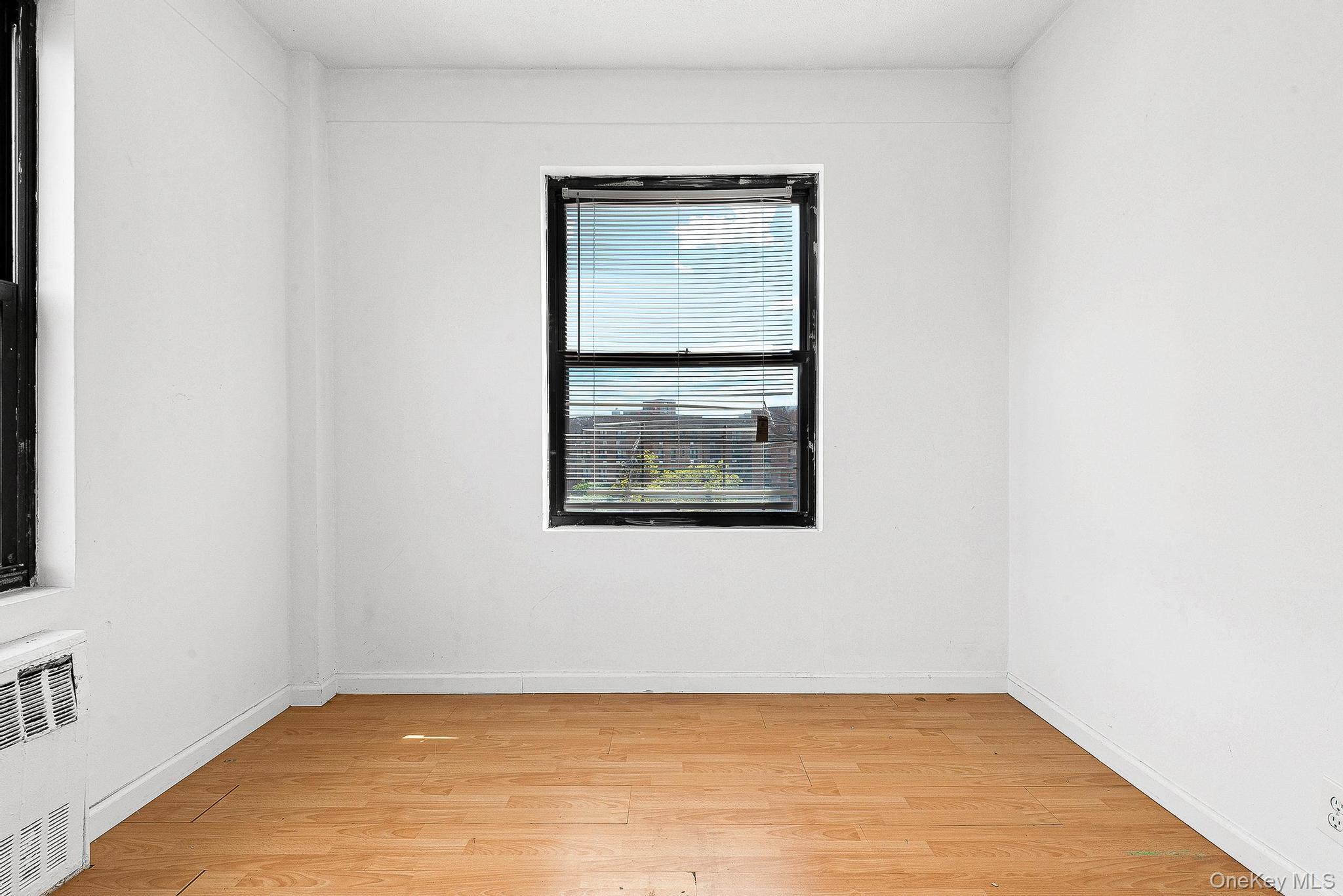 99-32 66th Road, Unit 5B Queens, NY 11374 - Photo 5 of 27 Spare room with light wood-style flooring and radiator heating unit
