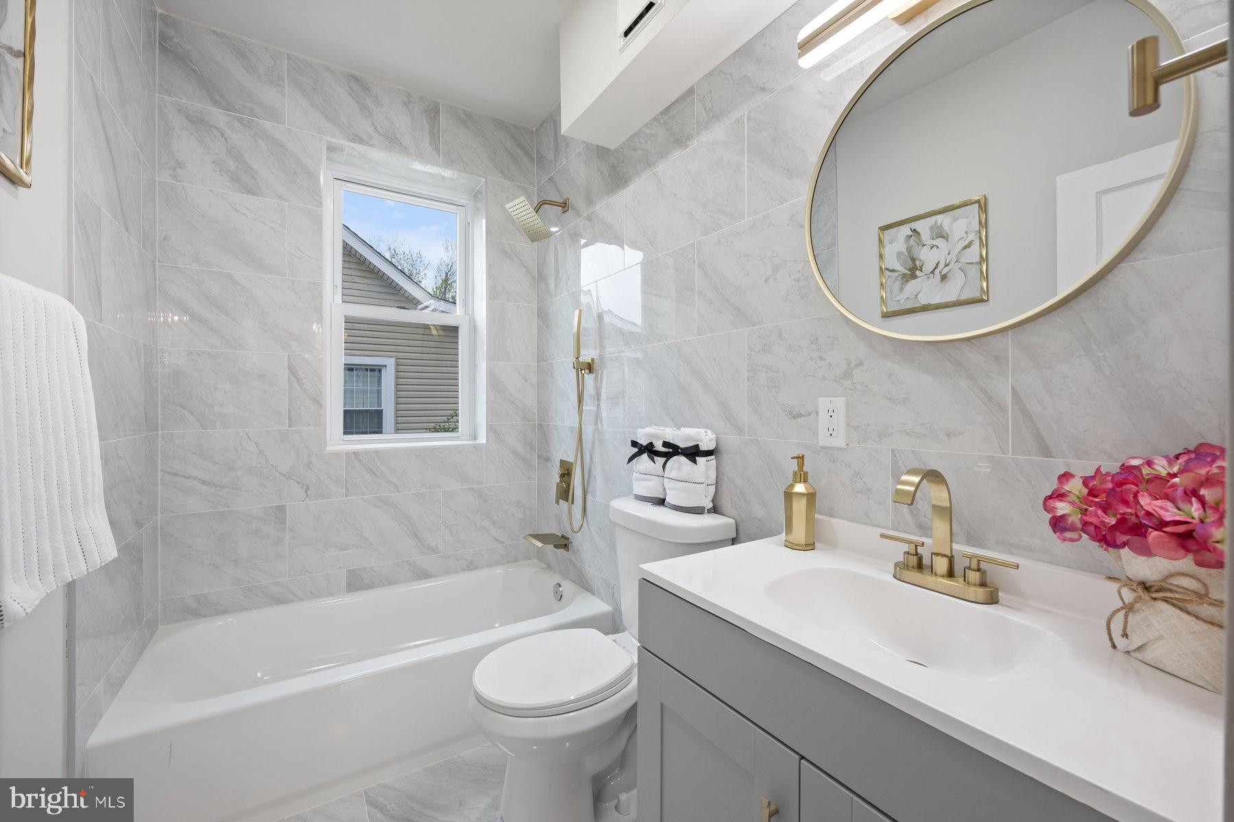 5512 Tramore Road Baltimore, MD 21214 - Photo 17 of 37 a bathroom with a sink mirror toilet and bathtub