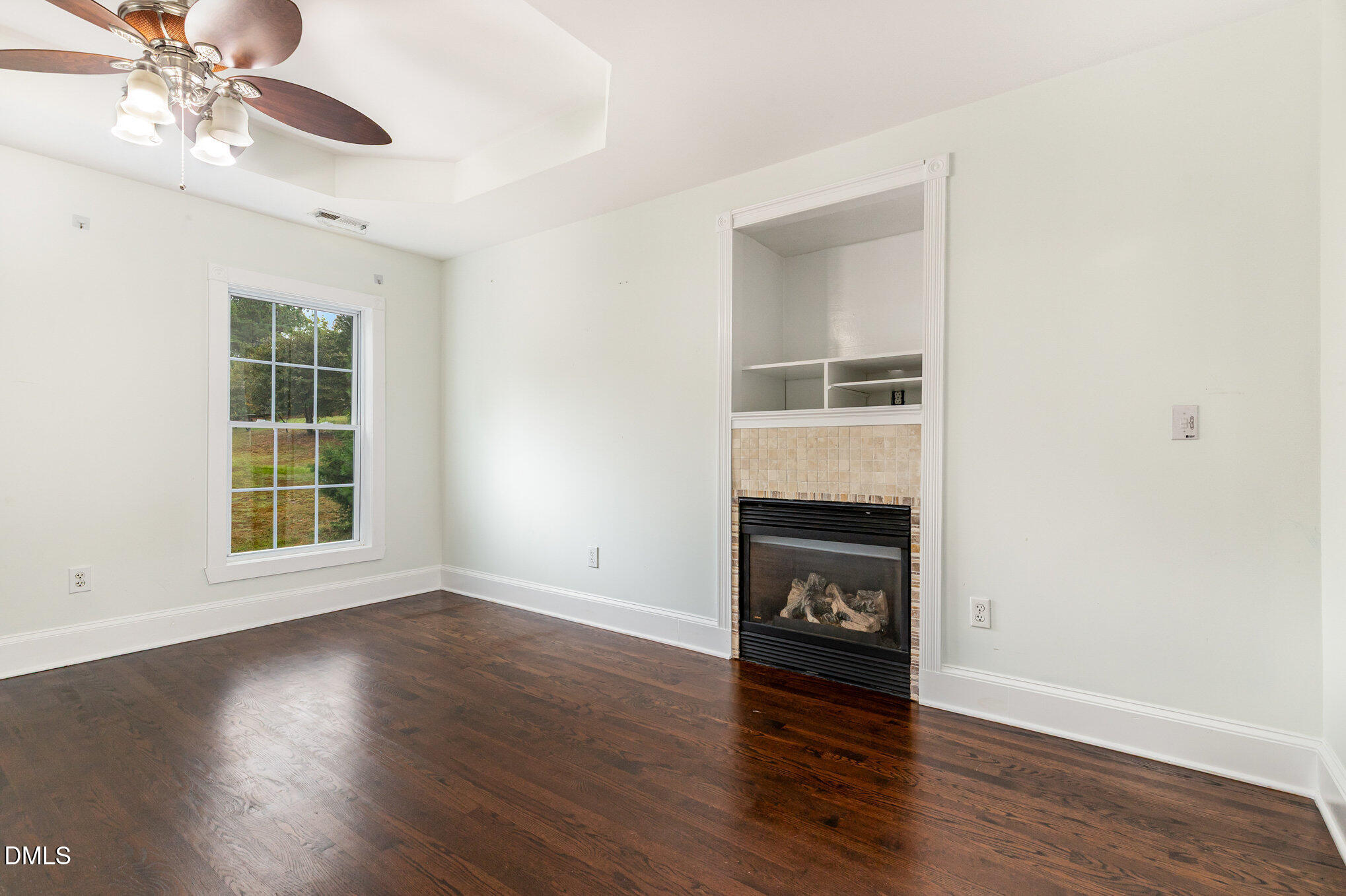 9261 Blackley Lake Road Wake Forest, NC 27587 - Photo 20 of 41 a view of an empty room with wooden floor fireplace and a window