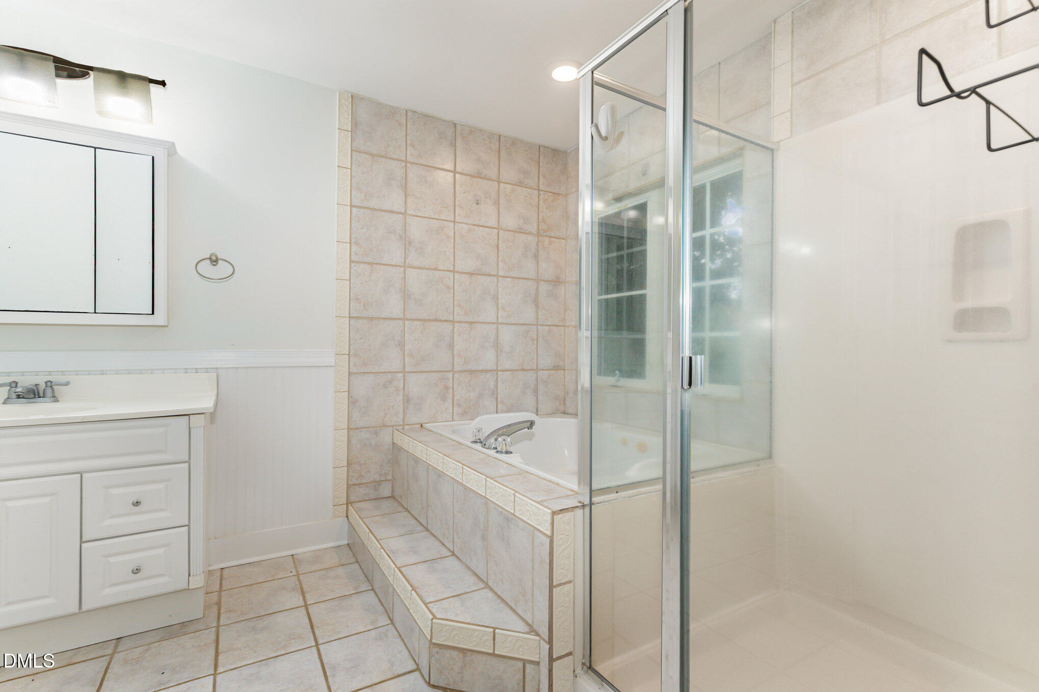 9261 Blackley Lake Road Wake Forest, NC 27587 - Photo 23 of 41 a bathroom with a bathtub sink vanity and mirror