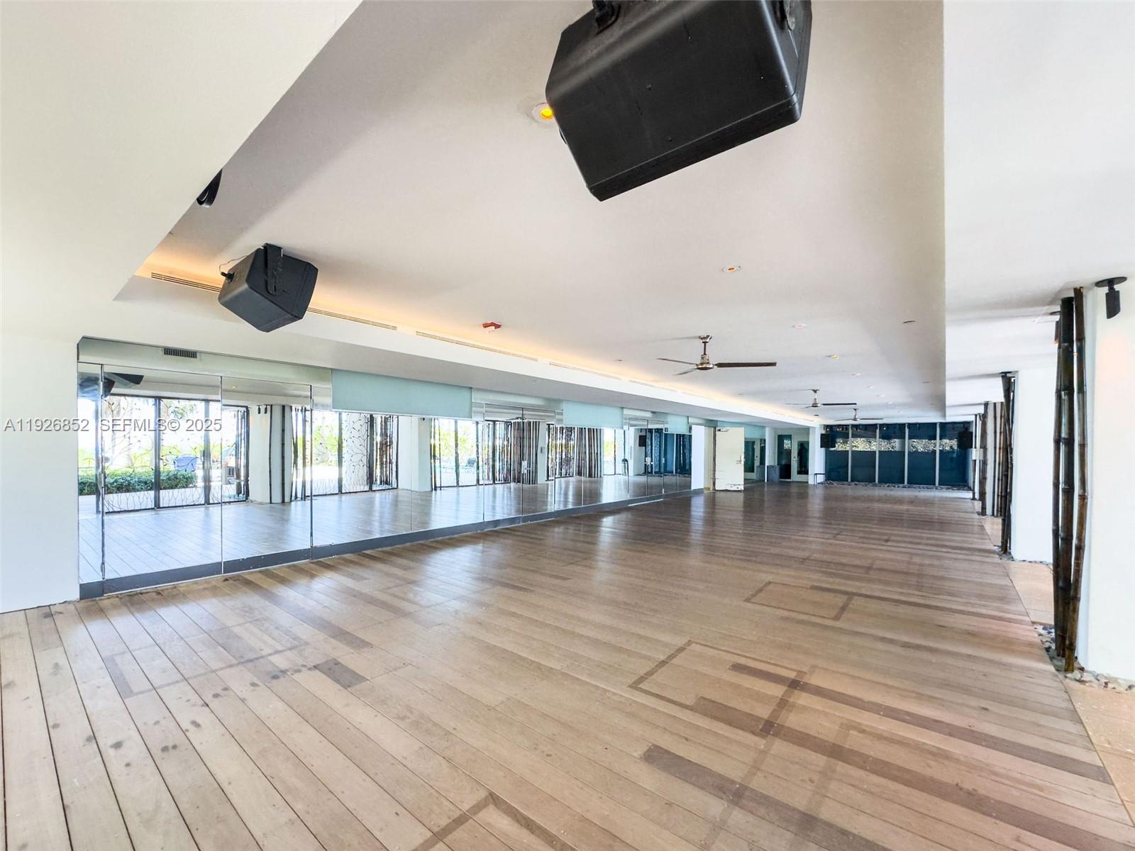 6801 Collins Avenue, Unit 614 Miami Beach, FL 33141 - Photo 18 of 49 an empty room with wooden floor and windows