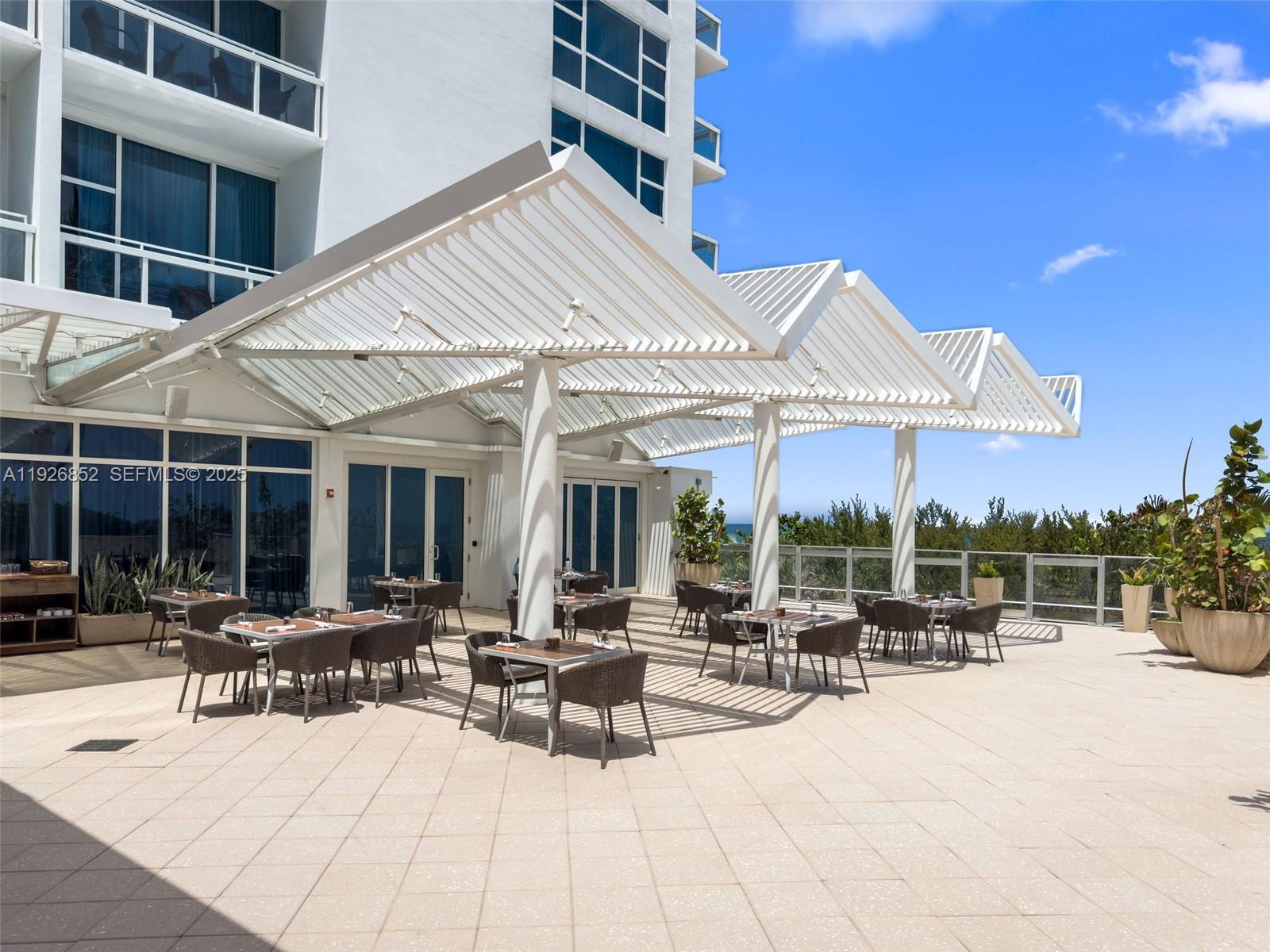 6801 Collins Avenue, Unit 614 Miami Beach, FL 33141 - Photo 32 of 49 a view of a patio with a table and chairs under an umbrella