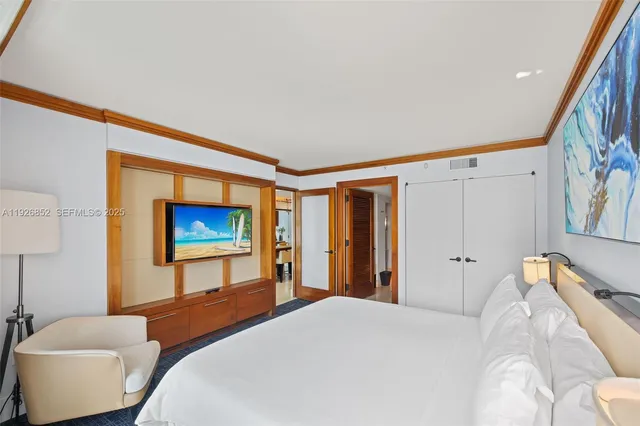 a bedroom with a bed and a flat screen tv