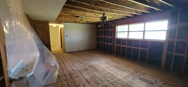 a view of empty room with wooden floor and windows