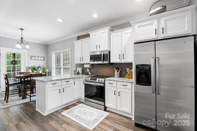 a kitchen with stainless steel appliances granite countertop a sink stove cabinets and wooden floor