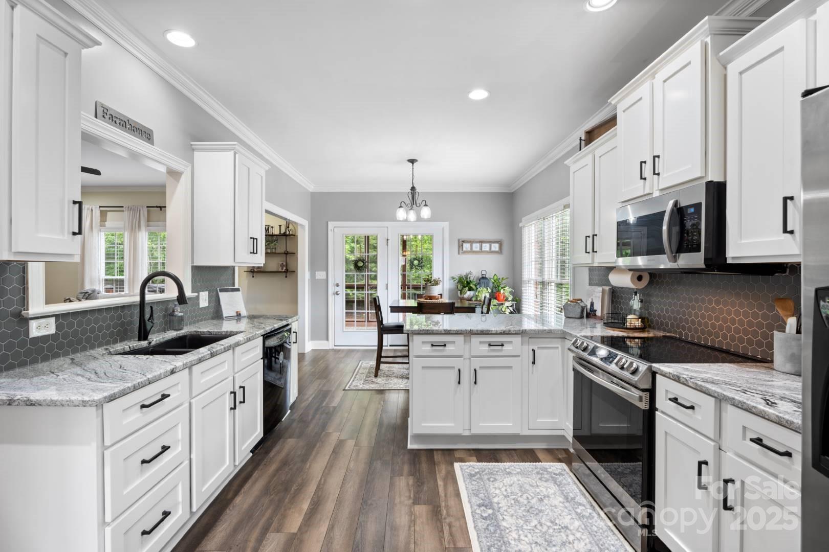 153 Canyon Road Mocksville, NC 27028 - Photo 17 of 46 a kitchen with stainless steel appliances granite countertop a sink stove cabinets and wooden floor