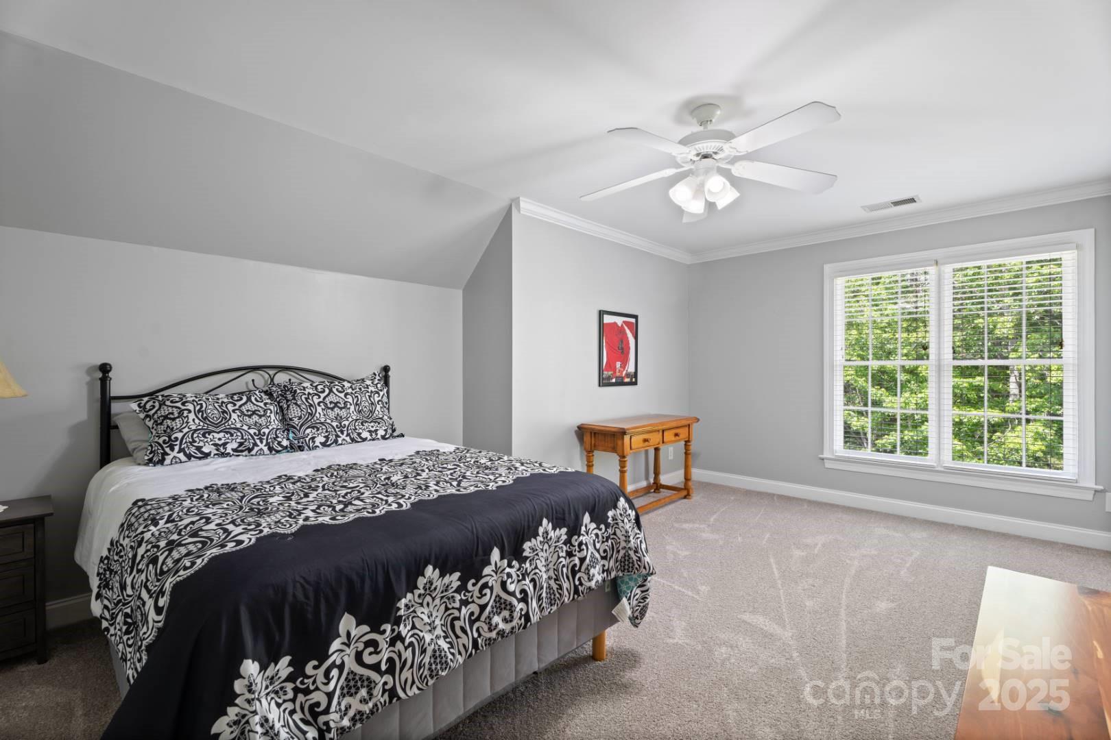 153 Canyon Road Mocksville, NC 27028 - Photo 32 of 46 a bedroom with a large bed and a chandelier