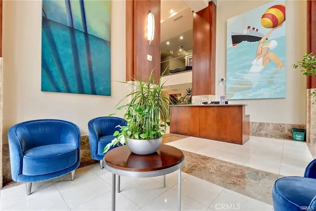 a living room with couches and kitchen view with wooden floor