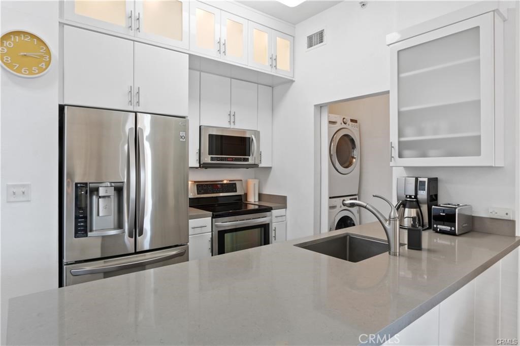 488 East Ocean Boulevard, Unit 618 Long Beach, CA 90802 - Photo 9 of 26 a kitchen with stainless steel appliances a sink a stove a microwave a refrigerator a counter space and cabinets