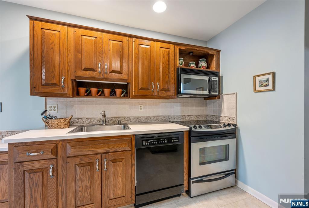 444B Bromley Place Wyckoff, NJ 07481 - Photo 12 of 26 a kitchen with stainless steel appliances granite countertop a stove a sink and a microwave