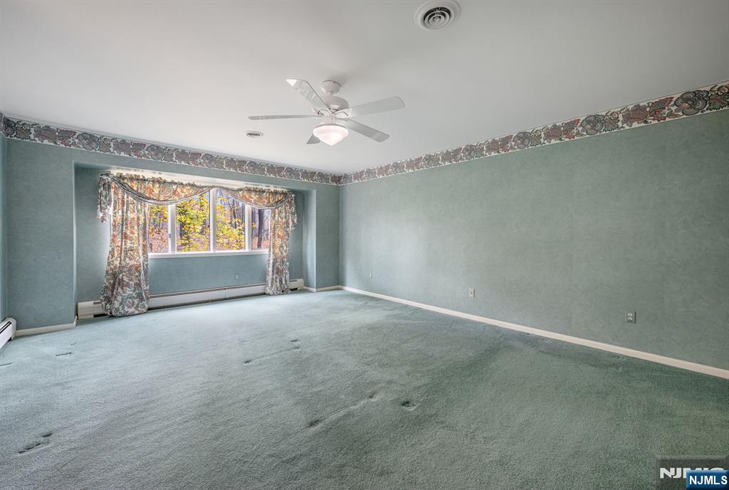 444B Bromley Place Wyckoff, NJ 07481 - Photo 16 of 26 an empty room with windows and ceiling fan