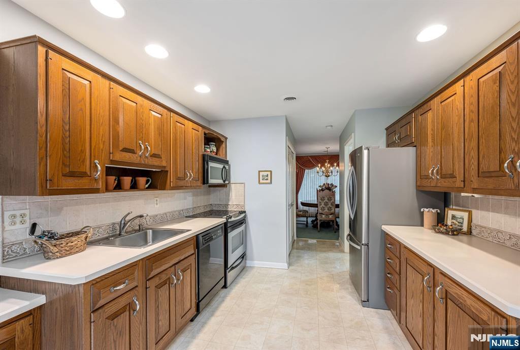 444B Bromley Place Wyckoff, NJ 07481 - Photo 9 of 26 a kitchen with stainless steel appliances granite countertop a sink stove and refrigerator