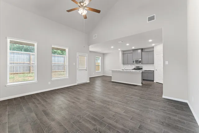 a view of kitchen with stove and white cabinets