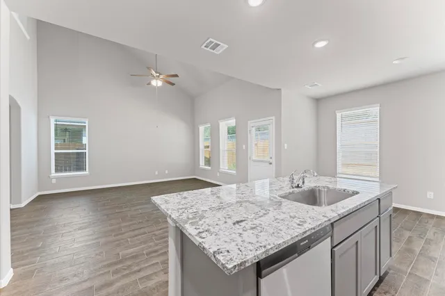 a kitchen with granite countertop a sink and a wooden floor