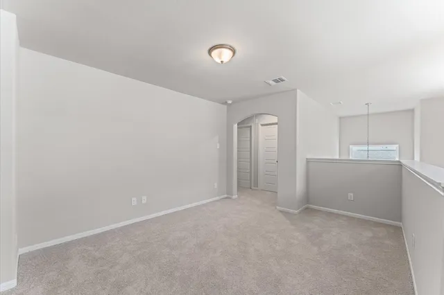 a view of an empty room and kitchen view