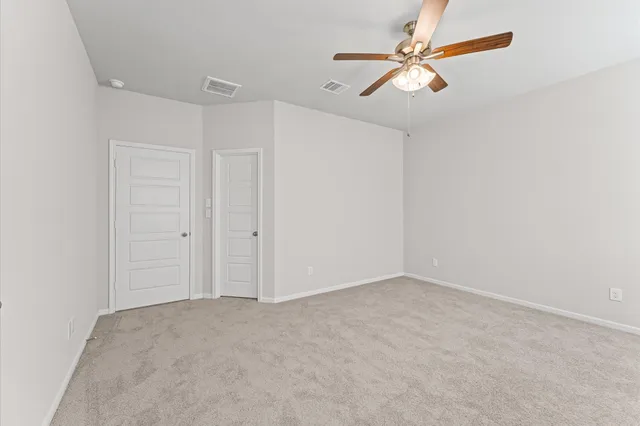 an empty room with chandelier fan