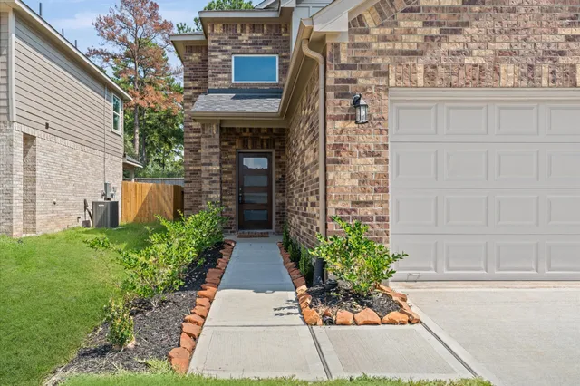 a front view of a house with a yard and potted plants