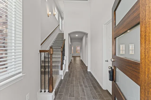 a view of a hallway with wooden floor and staircase