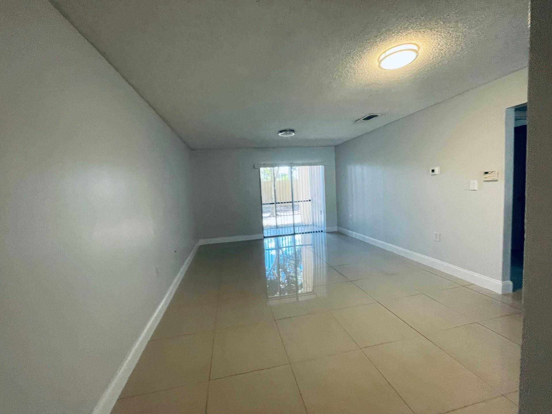 2201 Southwest 80th Terrace, Unit 2201 Miramar, FL 33025 - Photo 12 of 26 wooden floor in an empty room with a window