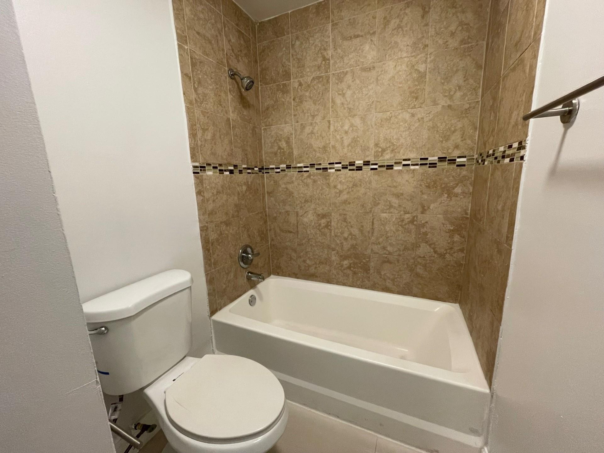2201 Southwest 80th Terrace, Unit 2201 Miramar, FL 33025 - Photo 16 of 26 a white toilet sitting next to a bath tub