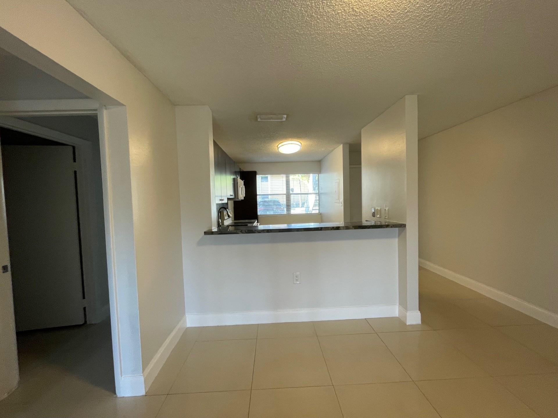 2201 Southwest 80th Terrace, Unit 2201 Miramar, FL 33025 - Photo 4 of 26 a view of an empty room and kitchen view
