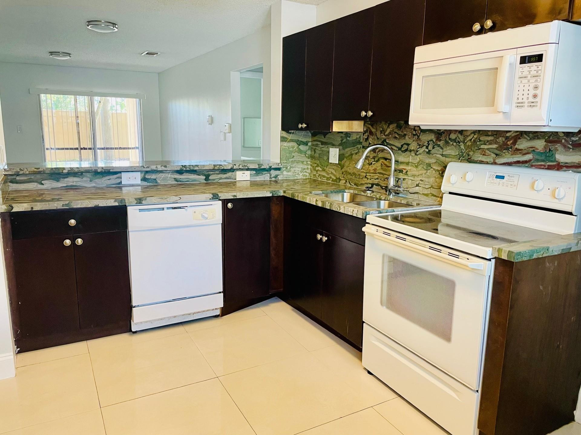 2201 Southwest 80th Terrace, Unit 2201 Miramar, FL 33025 - Photo 6 of 26 a kitchen with a stove sink and cabinets