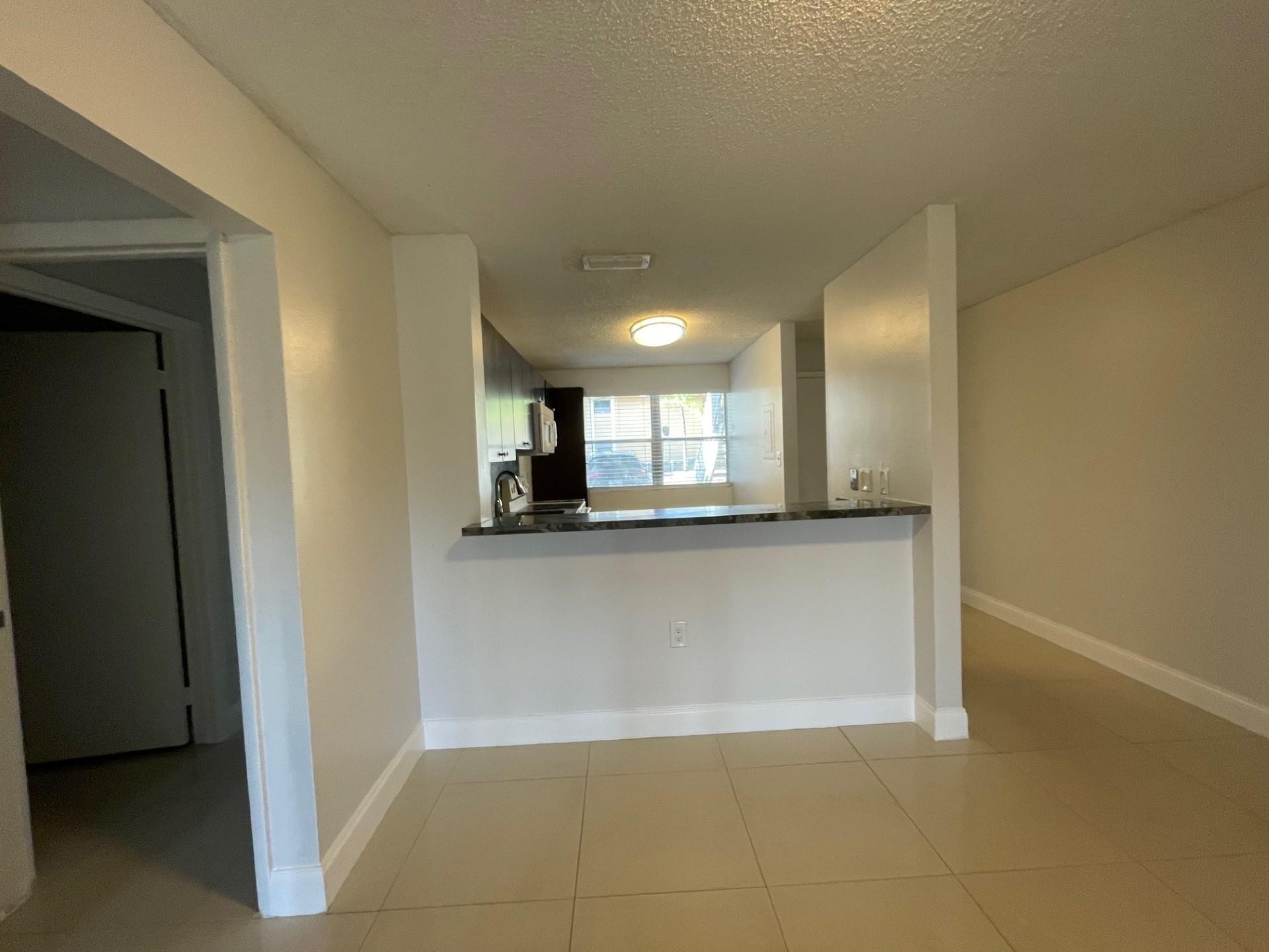 2201 Southwest 80th Terrace, Unit 2201 Miramar, FL 33025 - Photo 9 of 26 a view of a kitchen with a sink and a refrigerator