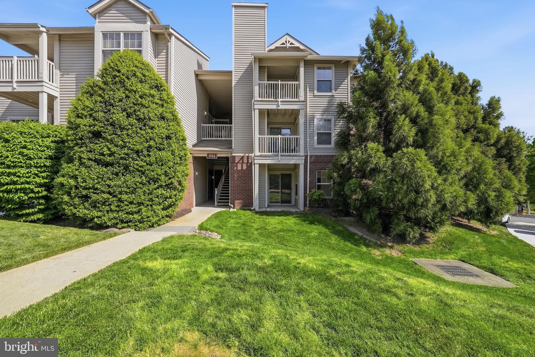 1703 Ascot Way, Unit D Reston, VA 20190 - Photo 1 of 21 a front view of a house with a yard and trees