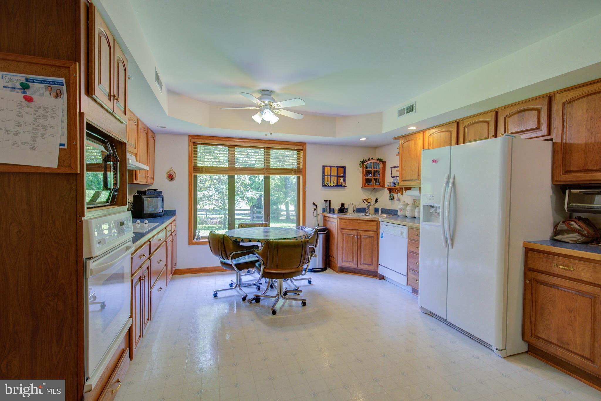 2619 Apple Pie Ridge Road Winchester, VA 22603 - Photo 15 of 29 a kitchen with stainless steel appliances kitchen island granite countertop a refrigerator a stove a dining table and chairs with wooden floor