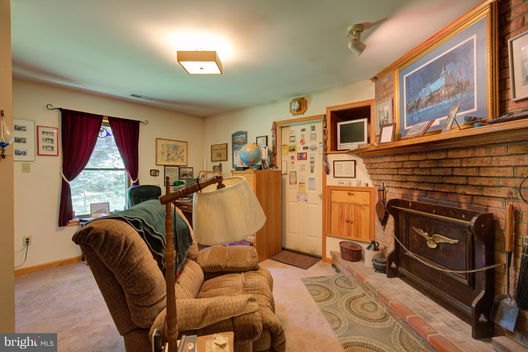2619 Apple Pie Ridge Road Winchester, VA 22603 - Photo 19 of 29 a living room with furniture a flat screen tv and a fireplace