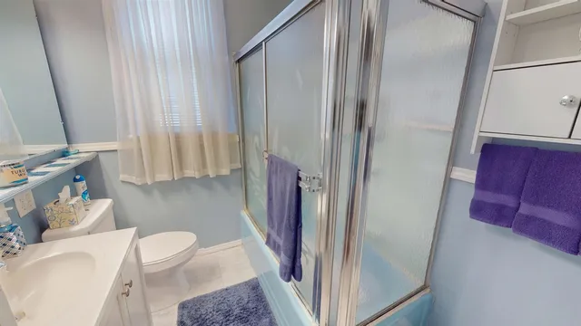 a bathroom with a sink a toilet a mirror and shower