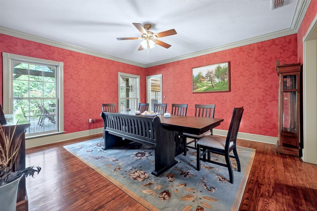 1901 Rose Pointe Athens, TX 75752 - Photo 8 of 37 Formal dining space featuring wood-finish flooring, patterned red wall coverings, and a ceiling fan with integrated lighting