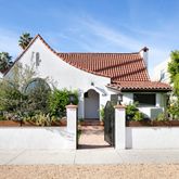 a view of a house with a yard and potted plants