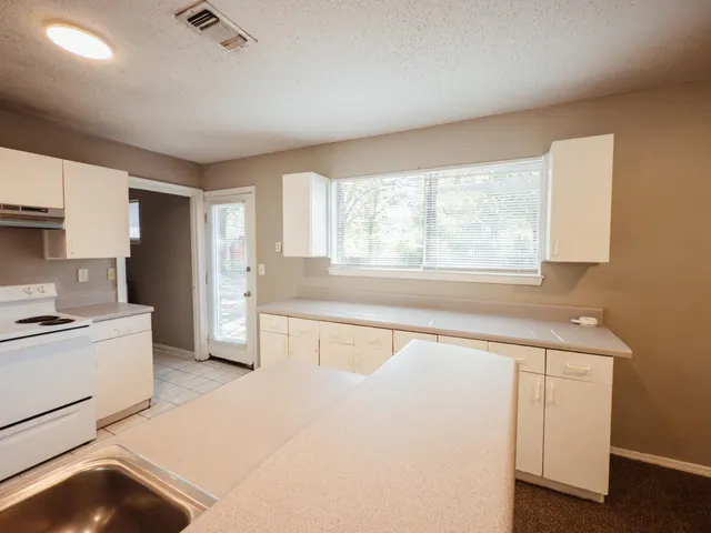 a kitchen with granite countertop white cabinets and white appliances