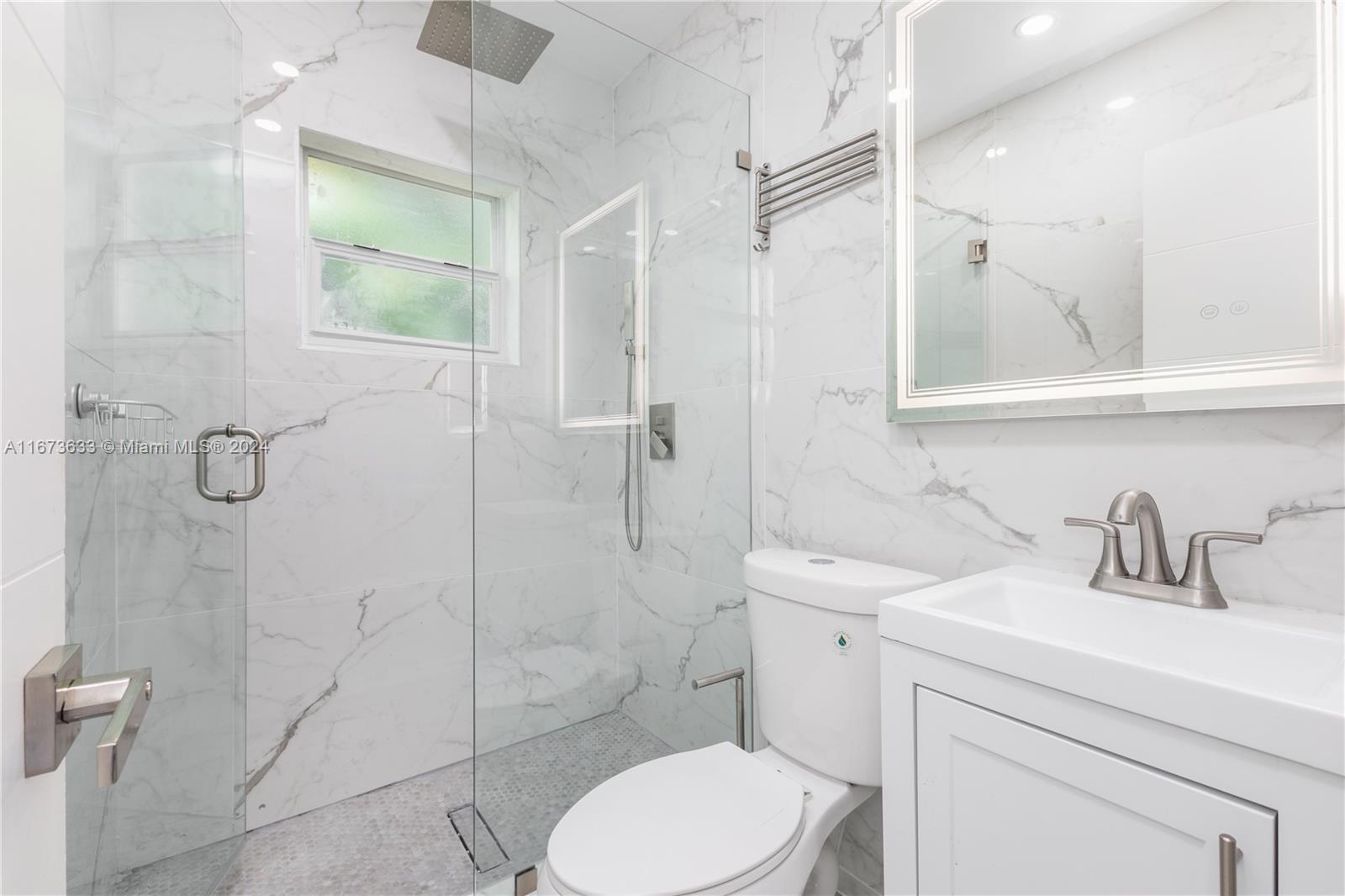 2320 Northwest 55th Street Miami, FL 33142 - Photo 13 of 34 a bathroom with a toilet sink shower and mirror