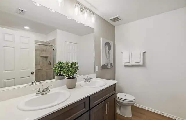 a bathroom with a sink a toilet and a mirror