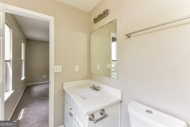 a bathroom with a sink a toilet and a mirror
