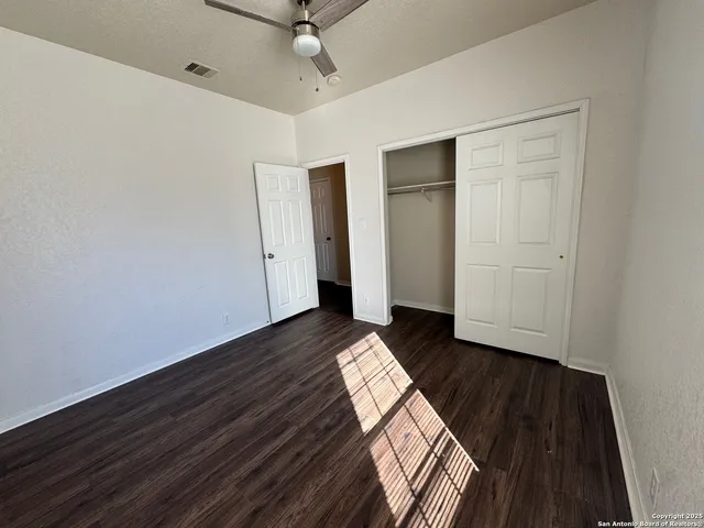 en empty room with wooden floor and windows