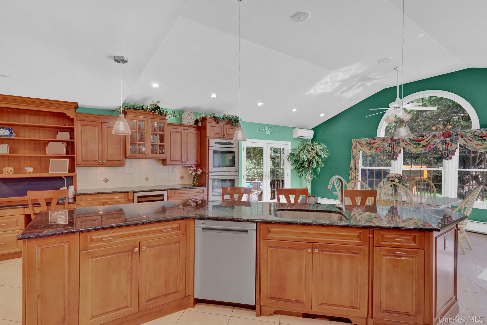 15 Stillwater Road Nissequogue, NY 11780 - Photo 12 of 43 Kitchen featuring a multi-level island with integrated sink, wood-finish cabinetry, built-in double oven, and recessed lighting