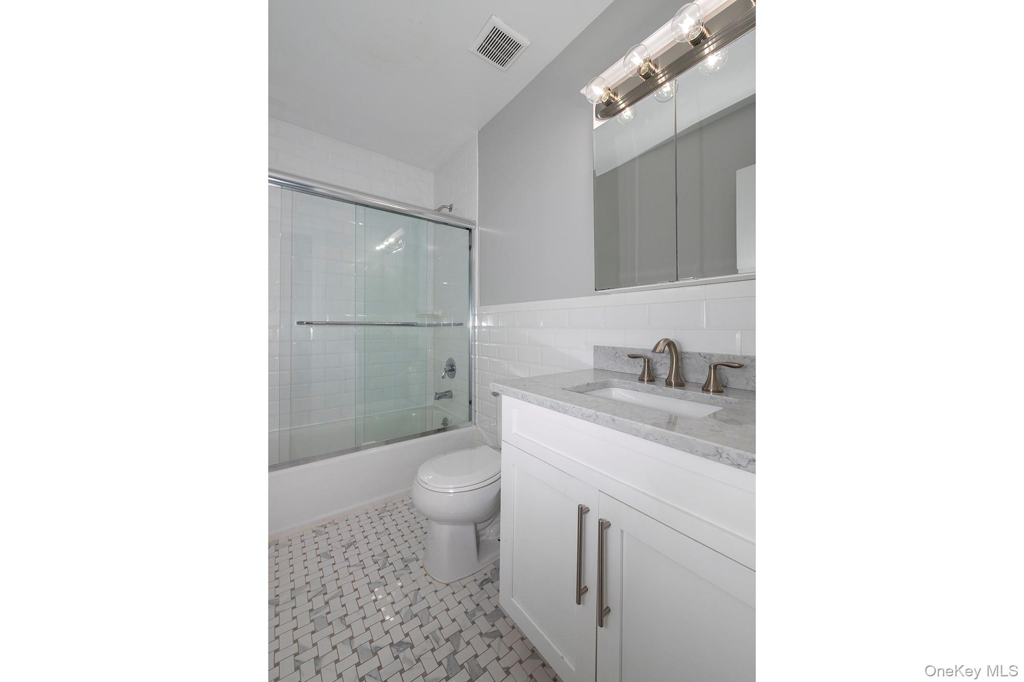 425 Newbridge Road, Unit 28 East Meadow, NY 11554 - Photo 8 of 8 a bathroom with a granite countertop sink a toilet and a mirror