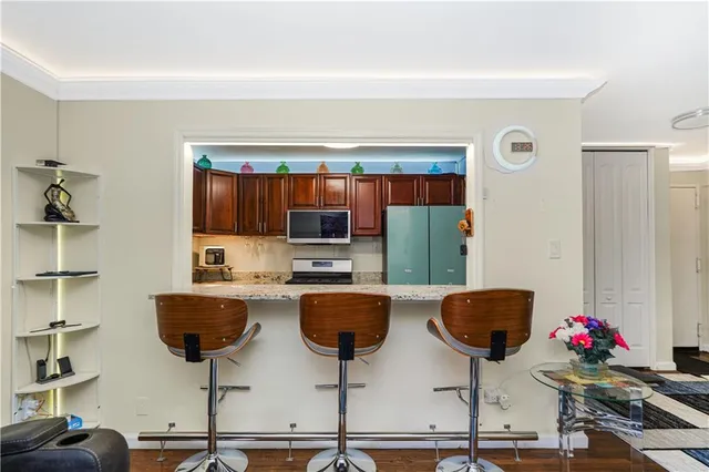 a kitchen with stainless steel appliances kitchen island granite countertop a cabinets and chairs
