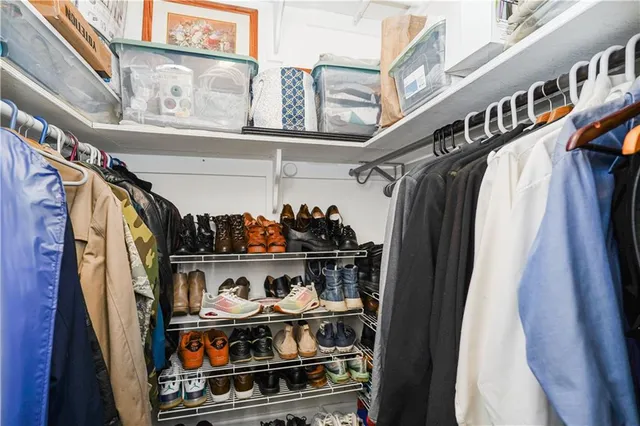 a view of walk in closet with clothes and shoes
