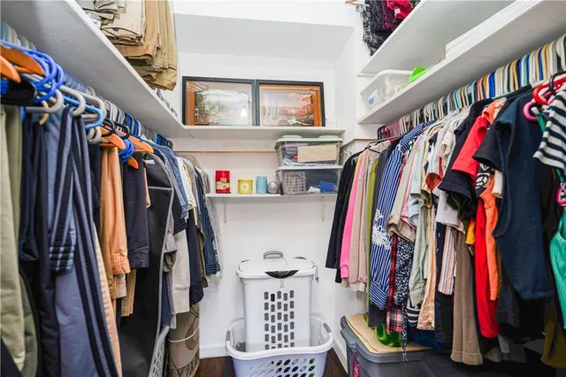 a view of walk in closet with clothes and shoes