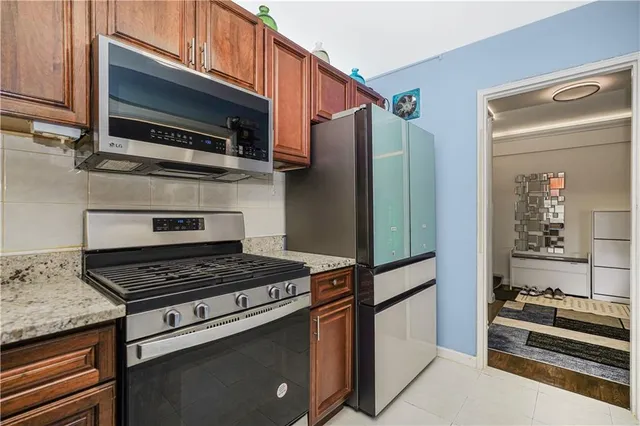 a kitchen with granite countertop a stove and a refrigerator