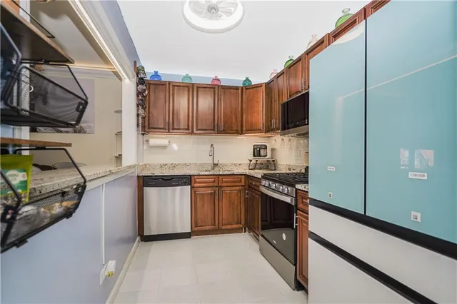 a kitchen with stainless steel appliances granite countertop a stove a sink and a refrigerator